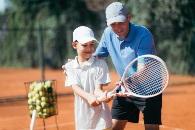 tennis-lesson-smiling-coach-explaining-tennis-technique-to-a-boy